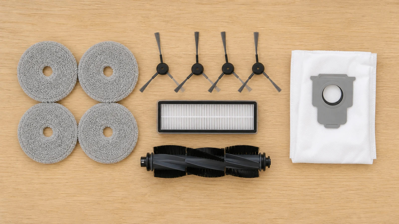 Organised flat-lay of robot vacuum mop pads, brushes, filter and dust bag accessories
